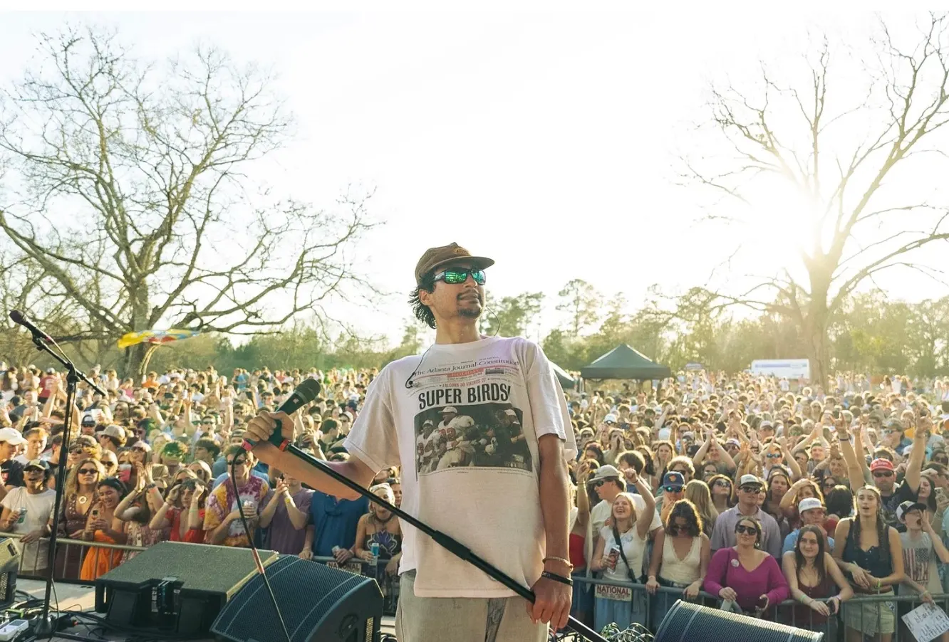 An artist looks out over the crowd at golden hour