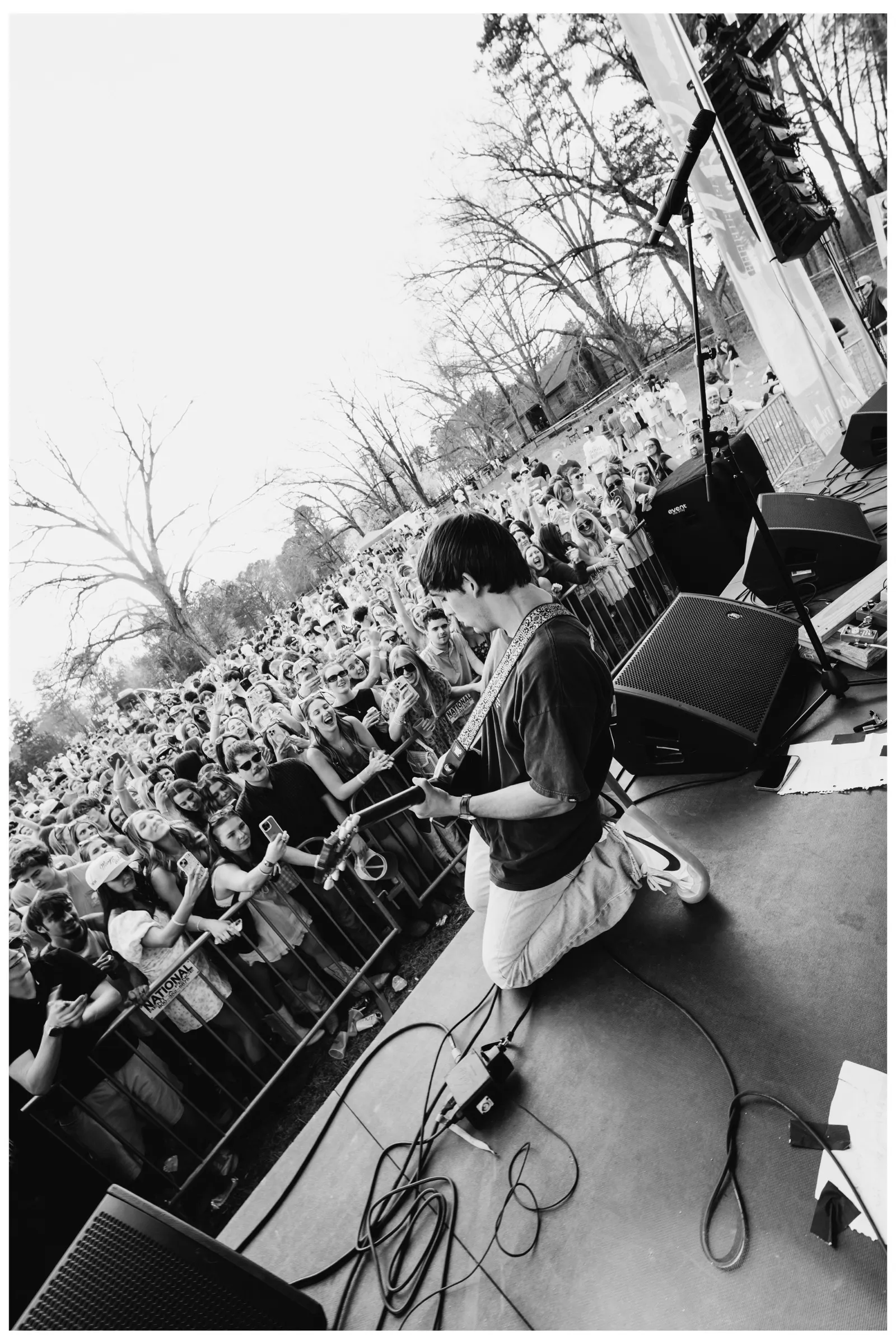 Black-and-white portrait of a guitarist playing to the crowd