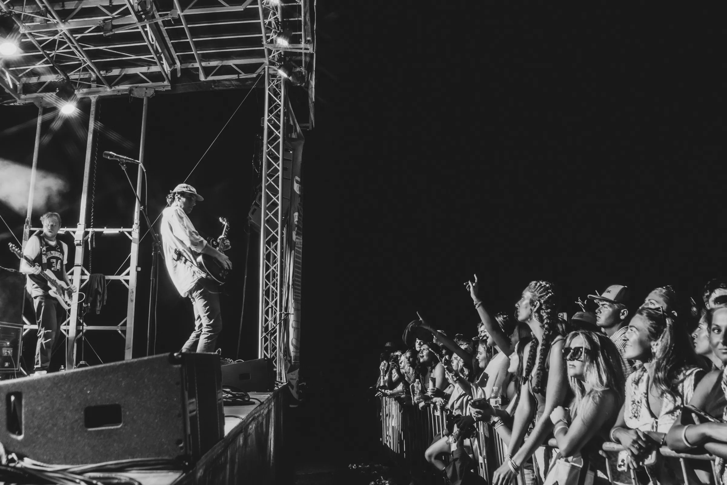Black-and-white night performance with the crowd reaching up