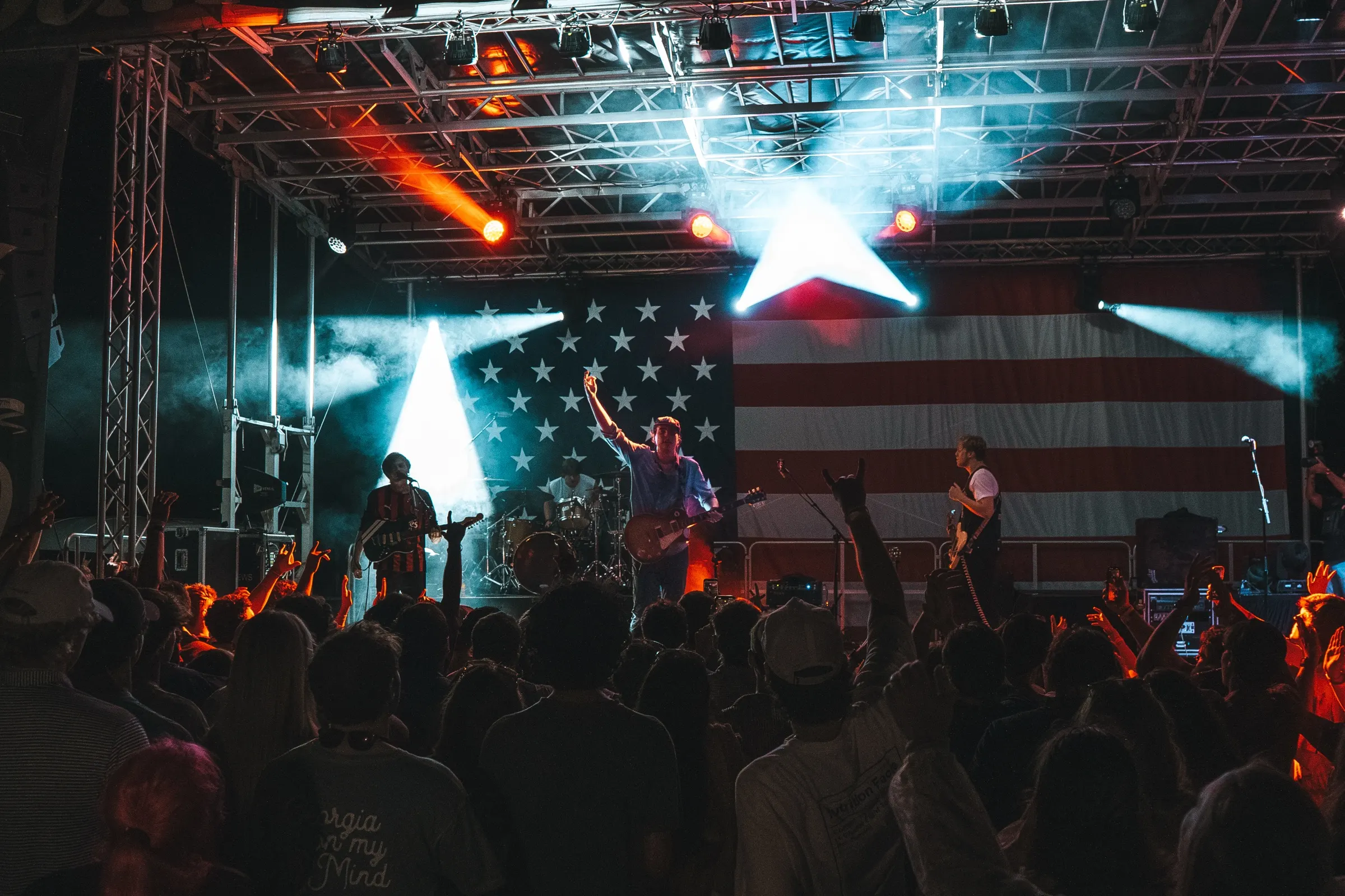 Spotlights and the flag backdrop during an evening set