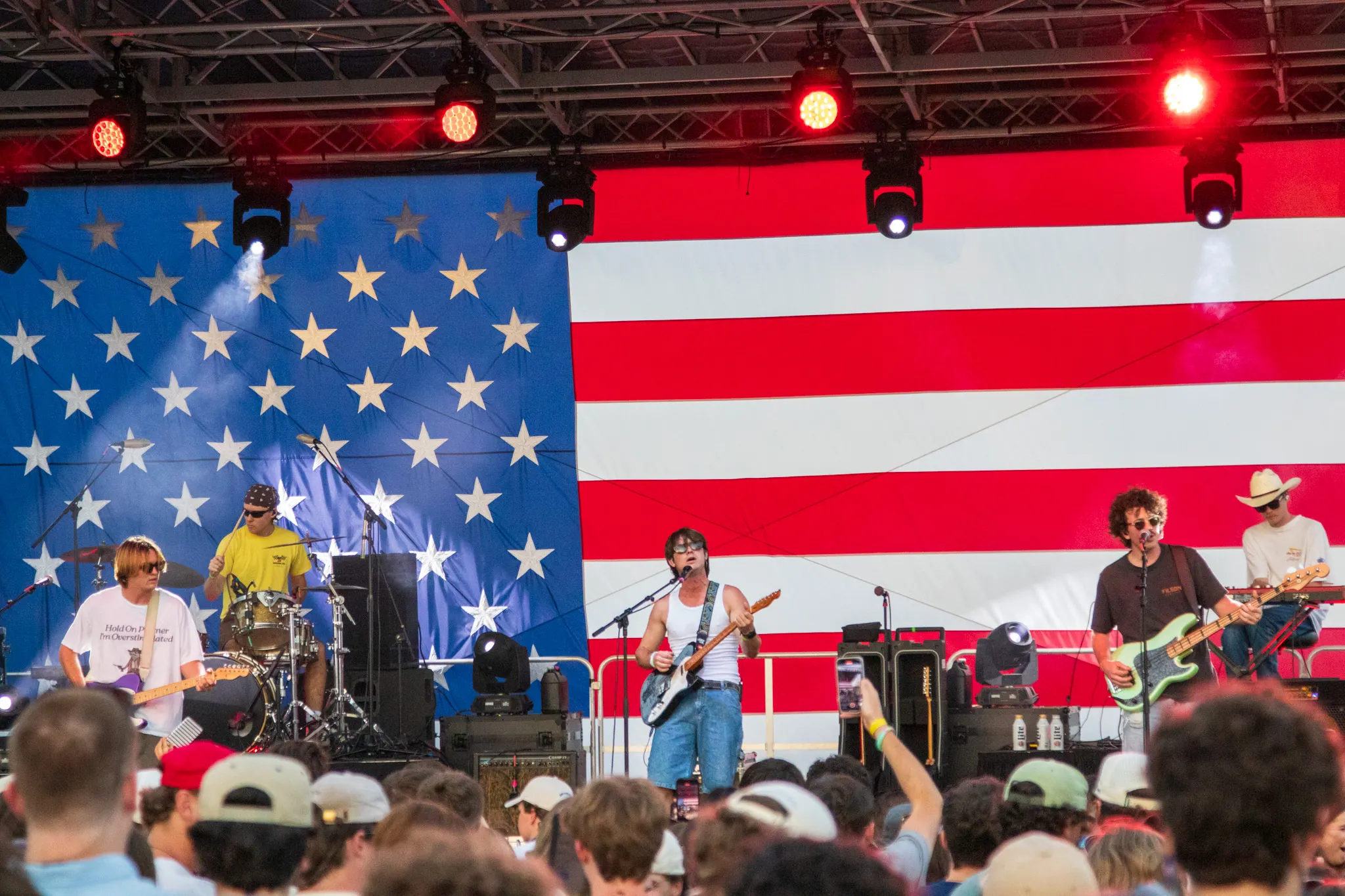 A band performs in front of a giant American flag backdrop